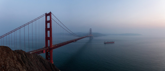 Beautiful panoramic view of Golden Gate Bridge during a hazy sunset. Taken in San Francisco,...