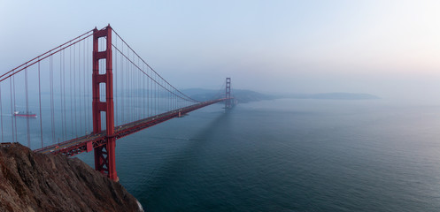 Beautiful panoramic view of Golden Gate Bridge during a hazy sunset. Taken in San Francisco, California, United States.