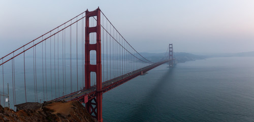 Beautiful panoramic view of Golden Gate Bridge during a hazy sunset. Taken in San Francisco, California, United States.