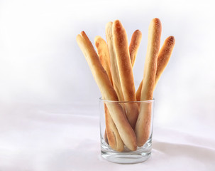 Long straight breadsticks are in a glass beaker