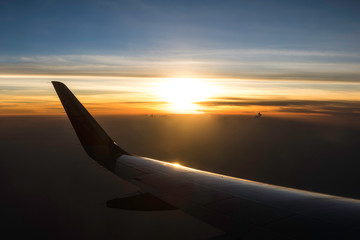 Sun rise early morning above plane wing