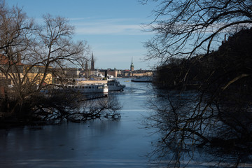 An sunny early spring day in Stockholm, view over a pier with boats and Town City Hall at lake Mälaren