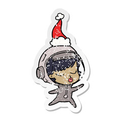 distressed sticker cartoon of a pretty astronaut girl wearing santa hat