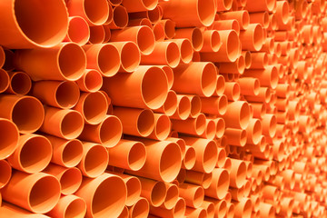 orange PVC pipes stacked in construction site