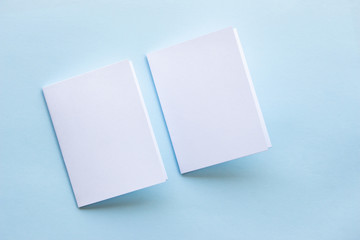 Blank portrait mock-up paper. brochure magazine isolated on blue, changeable background / white paper isolated on light blue paper.