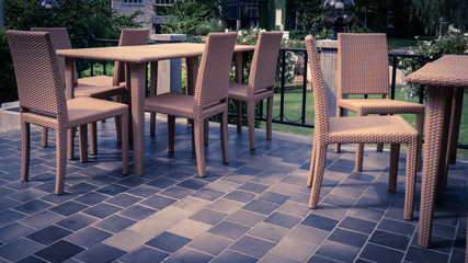 Fototapeta na wymiar Group of rattan chair and table on backyard terrace