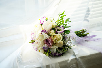 A bouquet of flowers for the bride lies on the windowsill