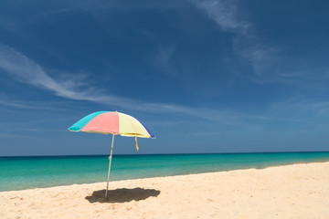 Fototapeta na wymiar Raise an beach umbrella on beautiful sunny day, clear sea and sky on background
