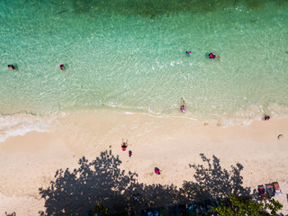 Aerial of tourism sunbathe, swiming and playing games on the beach at koh He or Coral island, Phuket, Thailand