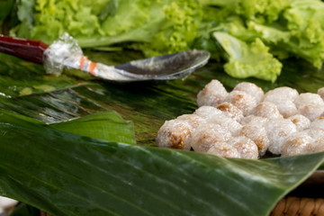 Tapioca balls with pork filling on banana leaf.