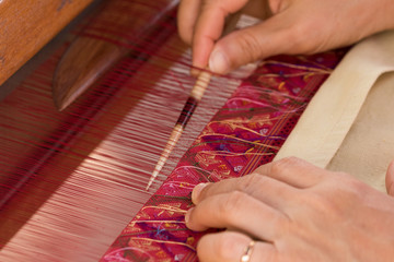 Women working on silk thread with traditional hand weaving loom