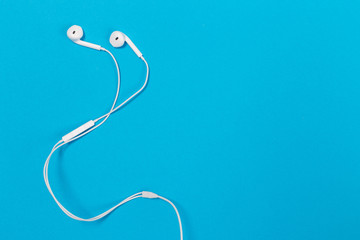 Headphones on pastel background. White headphones on a blue background.