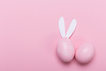 Pink easter eggs in nest on pastel color background with space. Concept