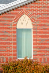 Arched window of a church with red brick wall