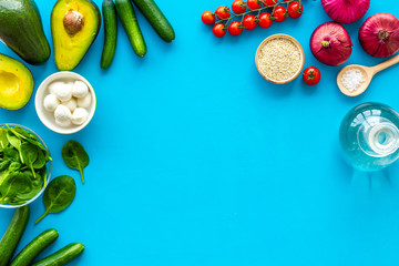 Fresh organic vegetables on blue background top view copy space. Kitchen desk for preparing salad