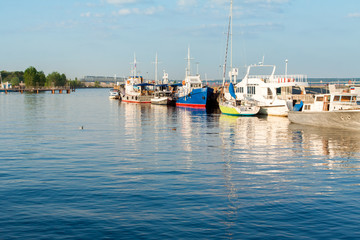 Boats near the shore reflected in the water.