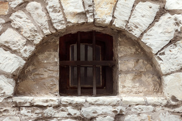 Old Window with bars in an Ancient Stone Building