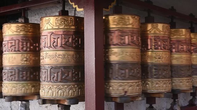 Prayer wheels in Jokhang temple. The characters (in Newari language & Tibetan) on the wheels are the mantras "Om Mani Padme Hum", each word means "sacred, bead, lotus flower, spirit of enlightenment"
