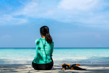Fototapeta premium Young beautiful woman in swimsuit sitting on white sand beach of andaman sea at summer sunny day