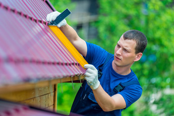 Professional worker repairs the roof of a residential building