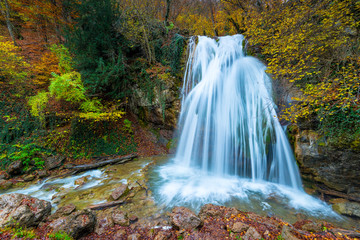 Fototapeta na wymiar Fast full-flowing waterfall Jur-Jur in the mountains of Crimea, a picturesque natural landmark in the fall, Russia