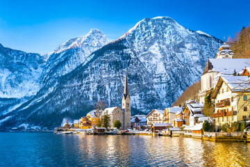 Classic postcard view of famous Hallstatt lakeside town in the Alps with traditional passenger ship...