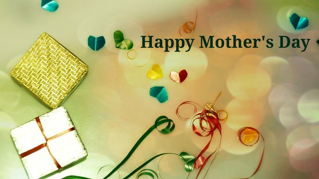 Happy Mother's Day words with Colourful heart shape ribbon and small gift boxes on colorful bokeh, flare background. Image noise and light 