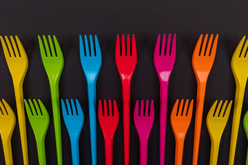 Many color plastic forks on a bright background