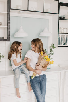  little girl gives flowers to mother on March 8