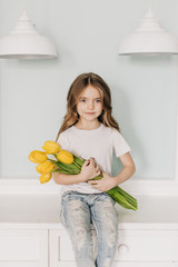 little beautiful girl with yellow tulips