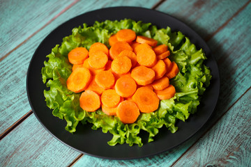 carrot sliced ​​on a plate and wooden background
