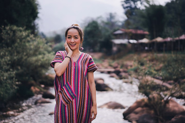 portrait of asian women in lanna uniform from thailand north in outdoor mountain and nature with river small in concept relaxing