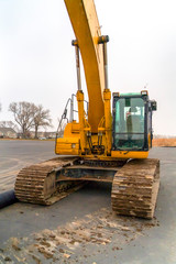 Excavator with dirty grouser pad parked on a road