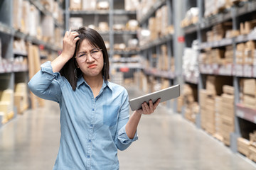 Young unhappy asian woman, auditor or employee looking and feeling confused in warehouse store. Portrait of young girl scratching her head, puzzled face and expressing doubt or uncertainty with work.