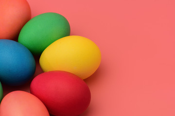 Fototapeta na wymiar Colorful Easter eggs lie on a pink background. Horizontal photography.