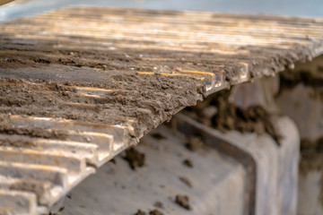 Grousers of an excavator with soil between bars