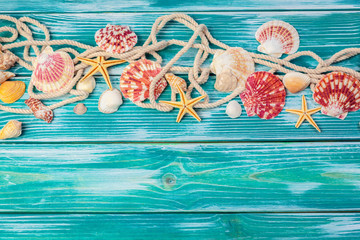 Naklejka premium Different sea shells on color wooden background