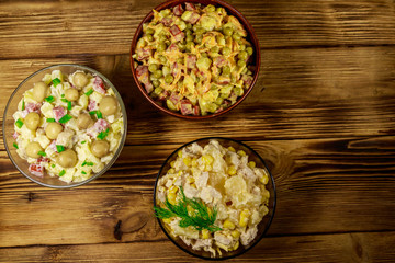 Set of festive mayonnaise salads on wooden table. Top view
