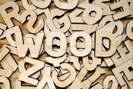 Board covered with random wooden letters and word WOOD on top.