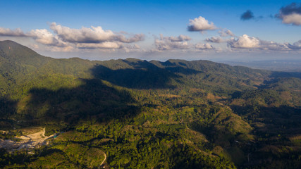 Fototapeta premium Valley top view in Thailand. Green jungle forest from drone view in Thailand. Shadows of clouds.