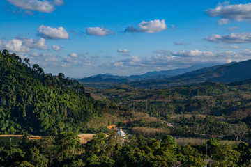 Obraz premium Aerial top view of the green hills valley and white Thai buddhist temple, Nakhon Si Thammarat, Thailand