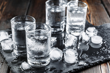 Vodka in shot glasses on rustic wood background