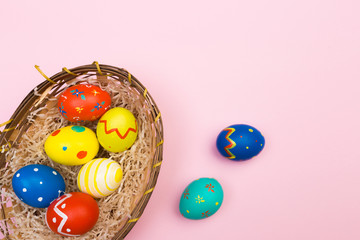 Fototapeta na wymiar easter eggs in basket on pink background