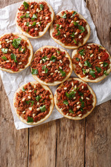 Lebanese Arab pizza with meat, tomatoes, spices and pine nuts closeup. Vertical top view