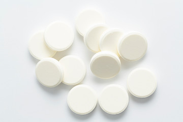 Top view of the Spilled white pills on the white background