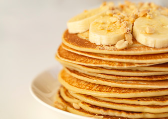 Sweet Homemade Stack of Pancakes with banana, nuts and honey. Delicious breakfast.