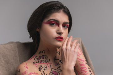 Brunette cute young model with red eyeshadows looking calm