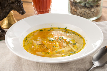 vegetarian cabbage soup with celery on white plate on textile napkin