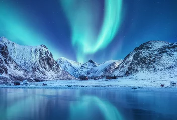 Crédence de cuisine en verre imprimé Aurores boréales Aurore boréale sur les îles Lofoten, Norvège. Aurores boréales vertes au-dessus des montagnes. Ciel nocturne avec aurores polaires. Paysage d& 39 hiver nocturne avec aurore et réflexion sur la surface de l& 39 eau. Norvège-image