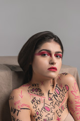Brunette cute young model with red eyeshadows feeling good